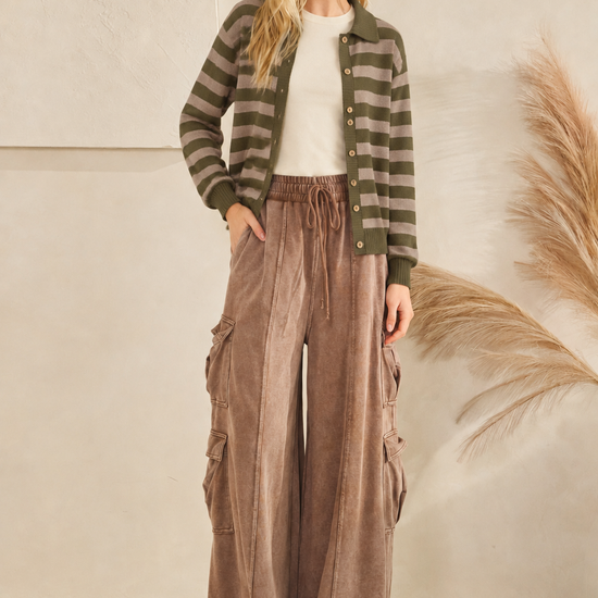 Olive and taupe collared button-up sweater layered over a cream T-shirt with brown wide-leg cargo pants