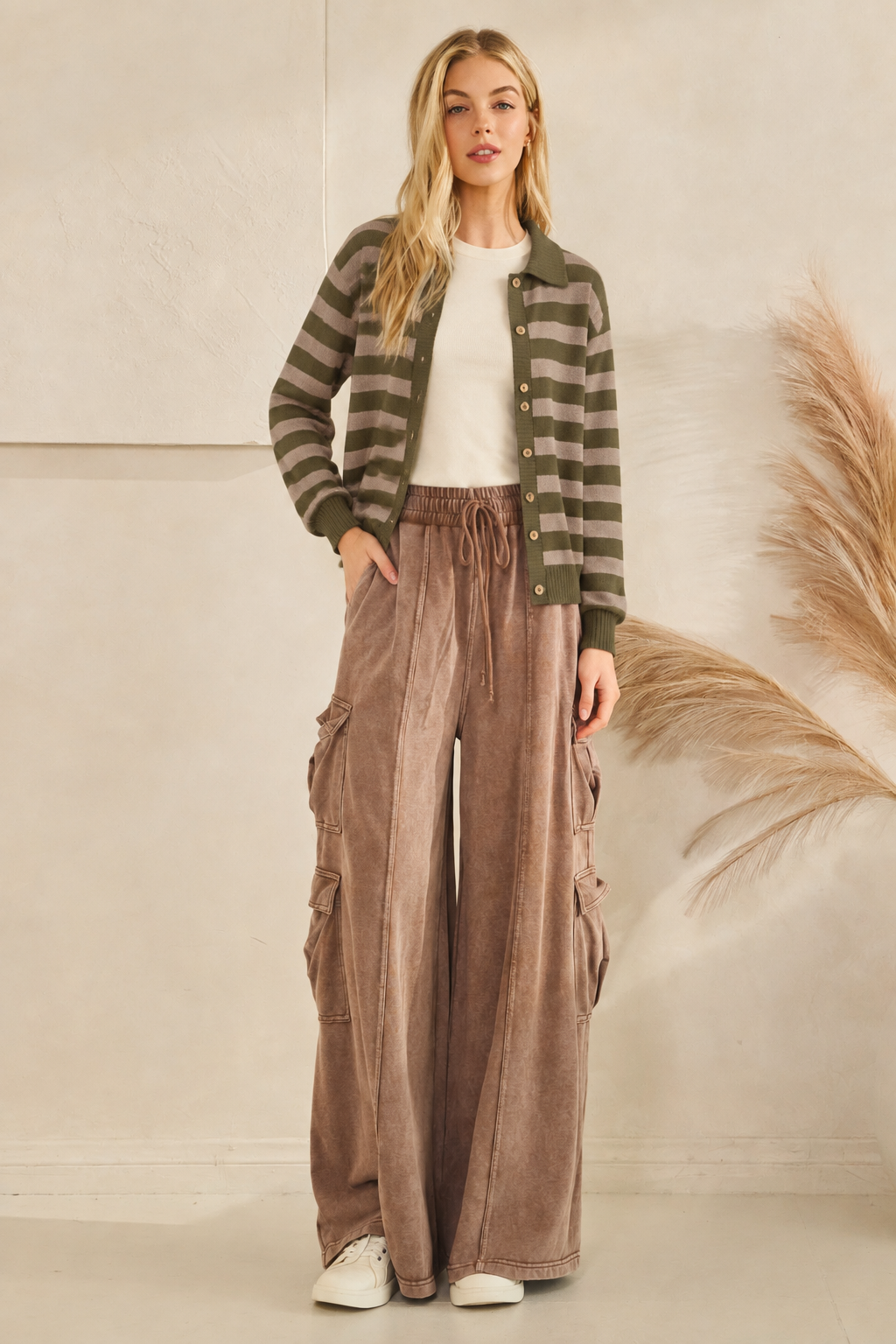 Olive and taupe collared button-up sweater layered over a cream T-shirt with brown wide-leg cargo pants