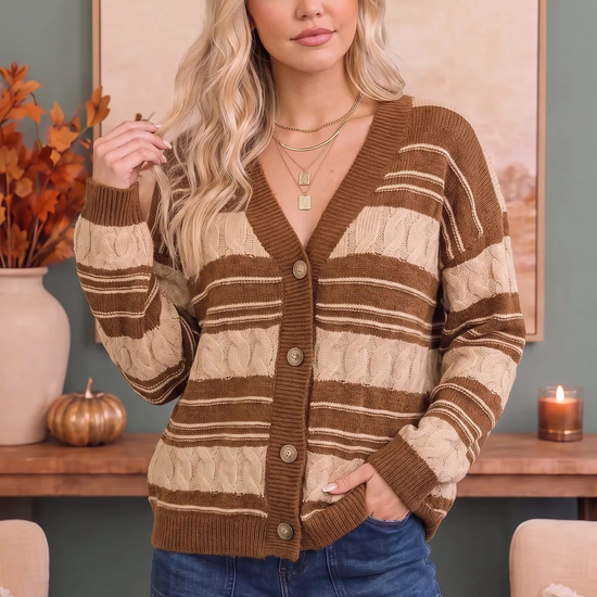 Front view of a woman wearing a brown and cream striped cable-knit button cardigan with blue jeans