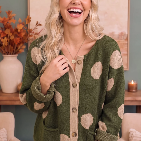 Model wearing an olive knit cardigan with cream polka dots and contrast trim
