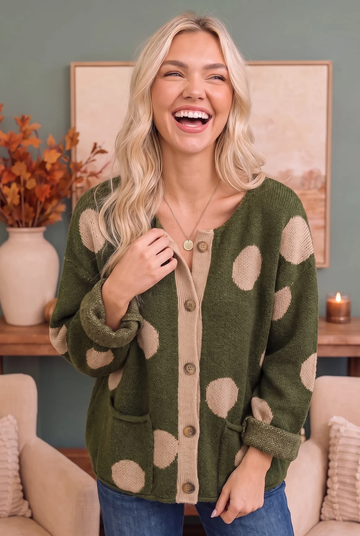 Model wearing an olive knit cardigan with cream polka dots and contrast trim