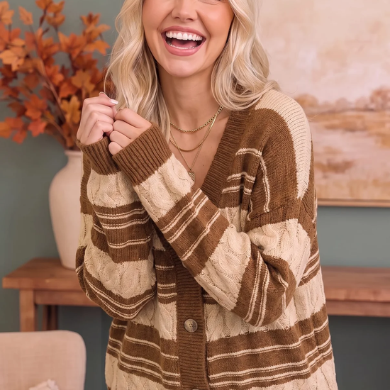 Smiling woman wearing a brown and cream striped cable-knit button-front cardigan with blue jeans