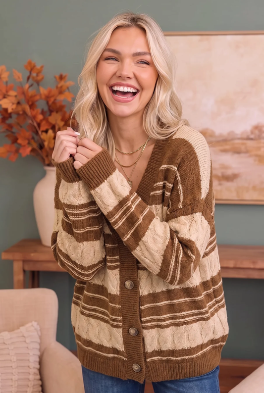 Smiling woman wearing a brown and cream striped cable-knit button-front cardigan with blue jeans